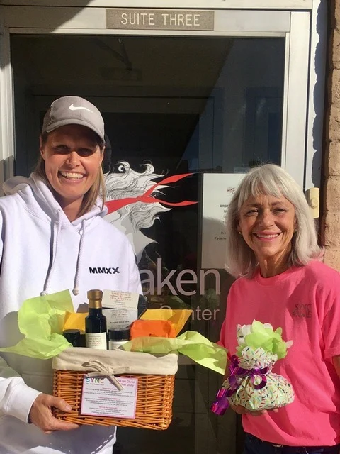 SYNC ladies presenting a basket to Awaken Reno