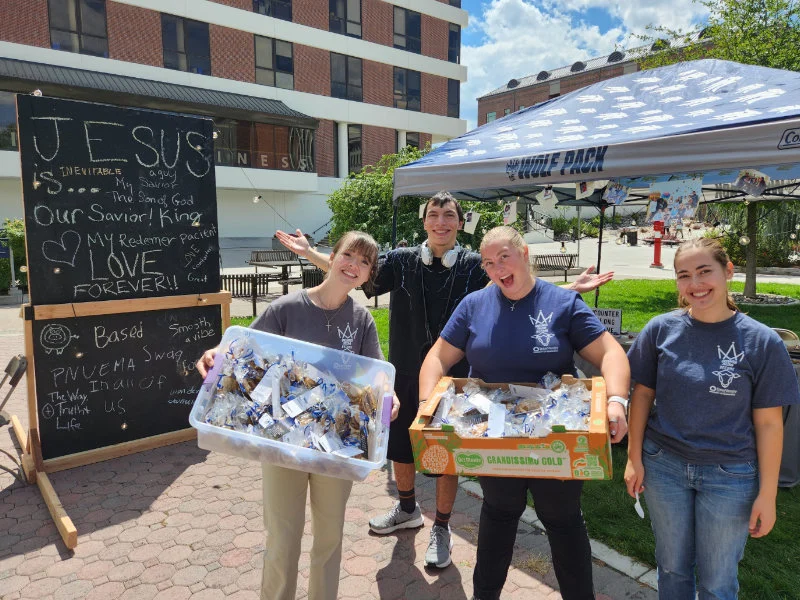 Students from InterVarsity Christian Fellowship holding cookie bags donated by SYNC.