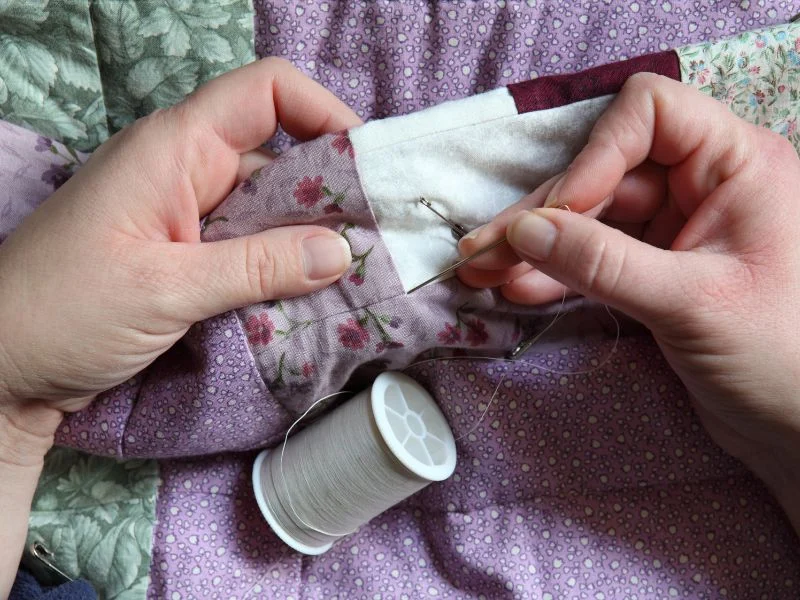 Woman hand quilting a quilt