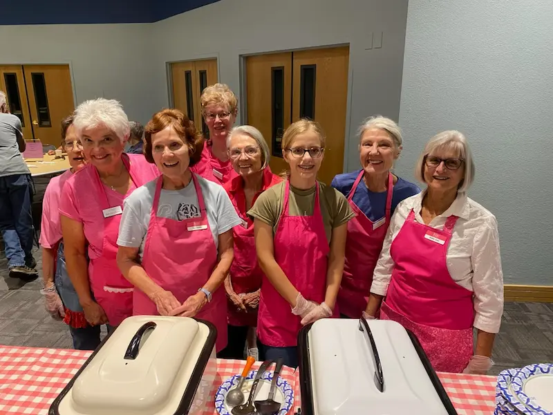 SYNC ladies posing in front of serving table