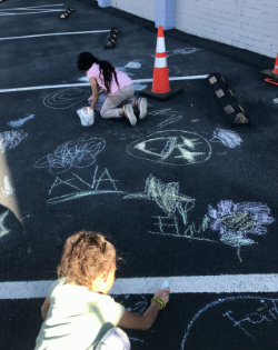 Children drawing with sidewalk chalk